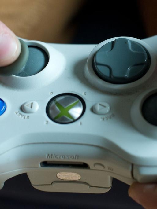 Eine Spielekonsole wird von zwei Händen gehalten. 