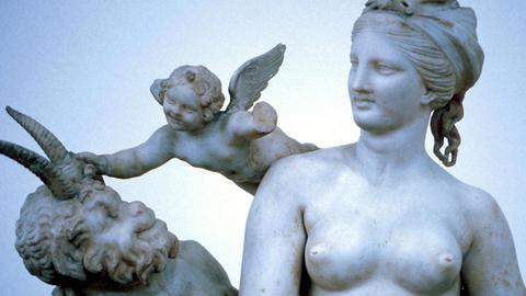 Altertümliche Skulptur im National Museum in Athen, die eine nakte Venus, einen kleinen beflügelten Knaben und einen gehörnten Satyr zeigt.