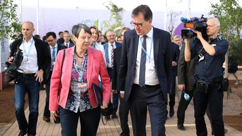 Barbara Hendricks und Gerd Müller gehen begleitet von einem Tross von Menschen auf die Kamera zu