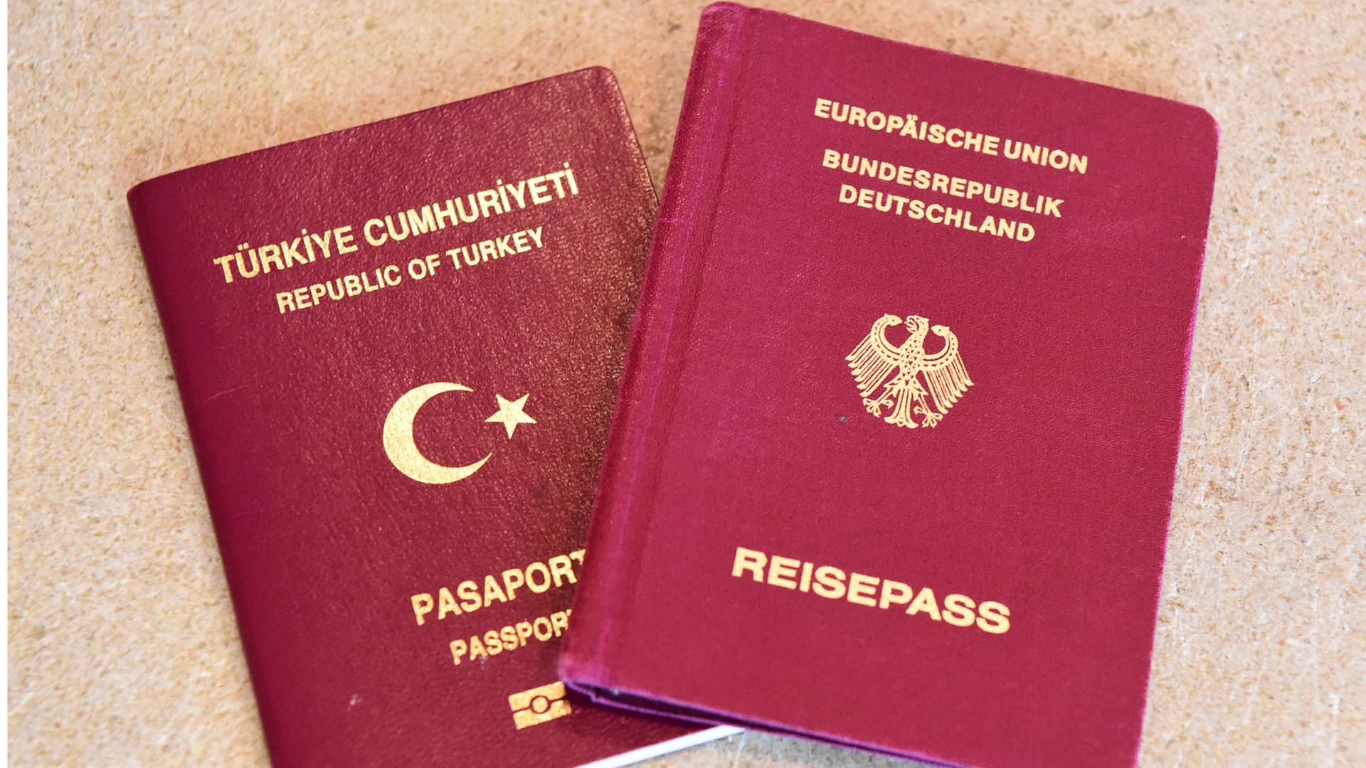 Ein deutscher und ein türkischer Pass werden liegen auf einem Tisch.