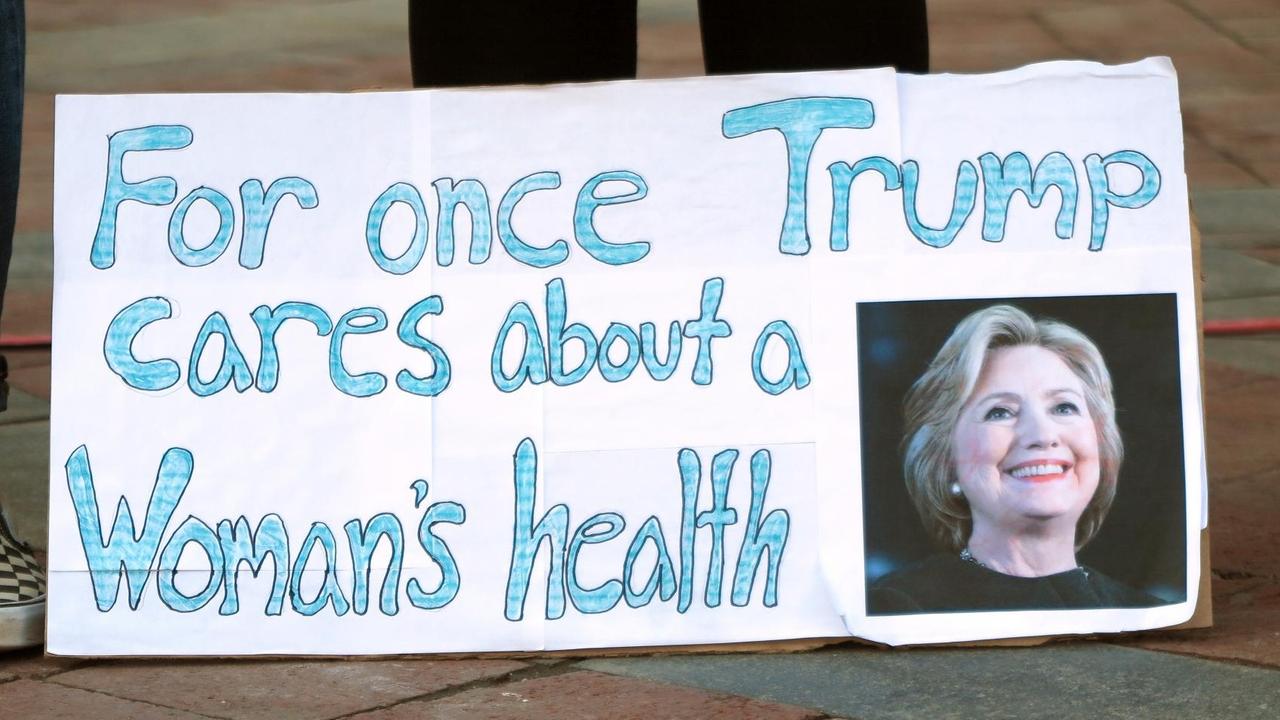 Ein Schild mit der Aufschrift "For once Trump cares about a Woman's health"("Ausnahmesweise sorgt sich Trump um die Gesundheit einer Frau") und einem Porträt von Hillary Clinton