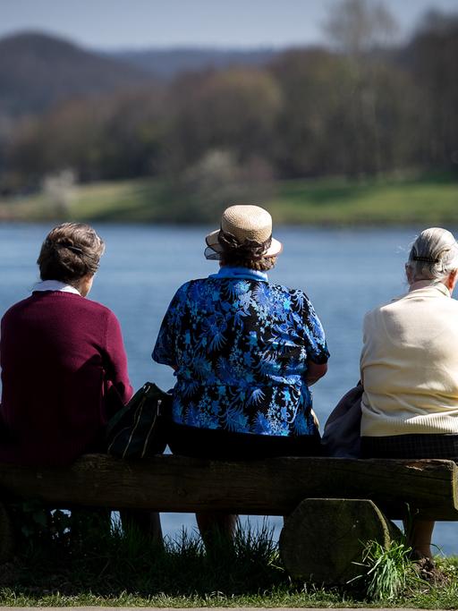 Drei Frauen sitzen am Kemnader See in Bochum in der Sonne.