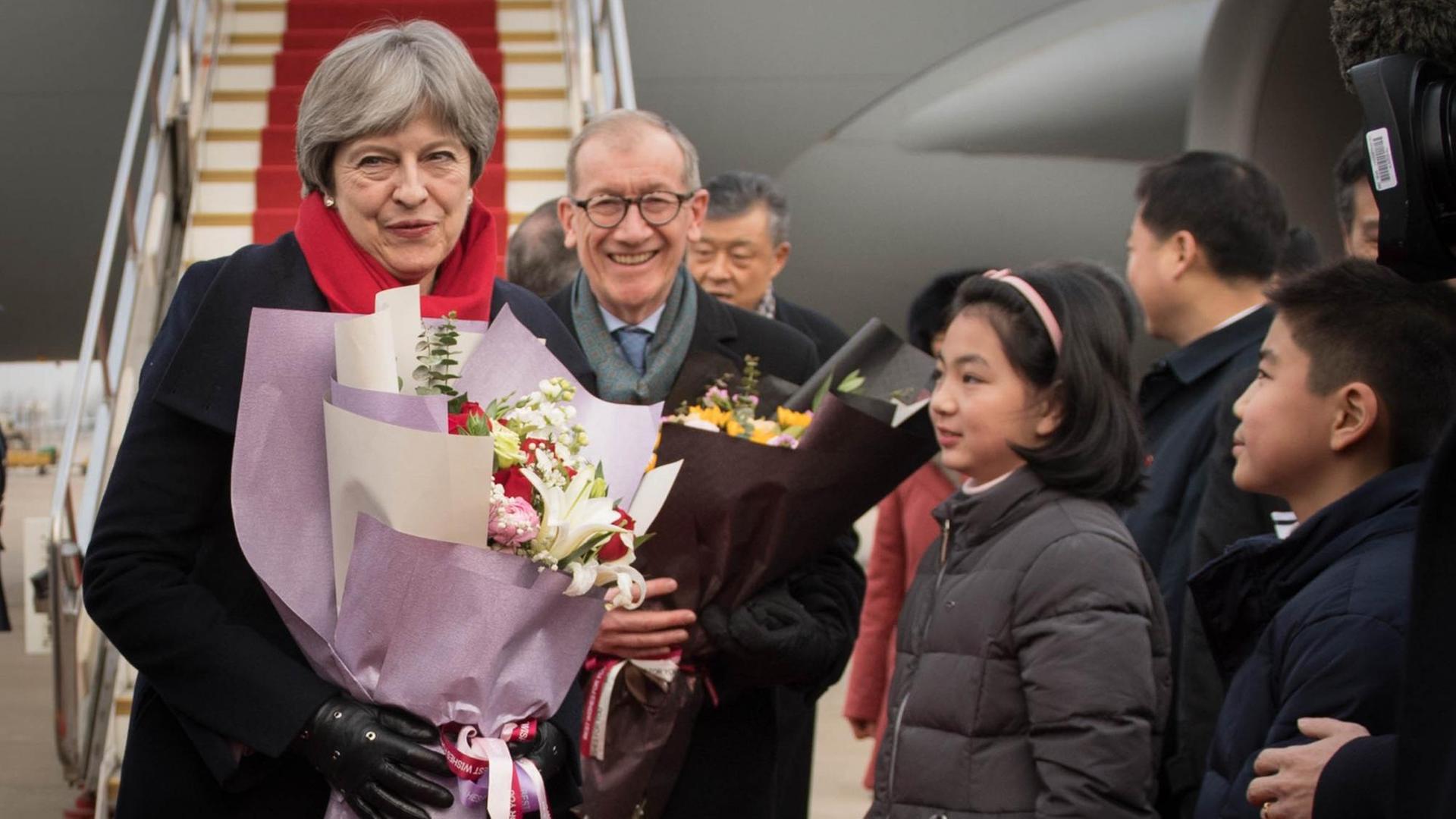 Die britische Premierministerin Theresa May und ihr Mann Philip kommen am Wuhan Tianhe internationalen Flughafen an.