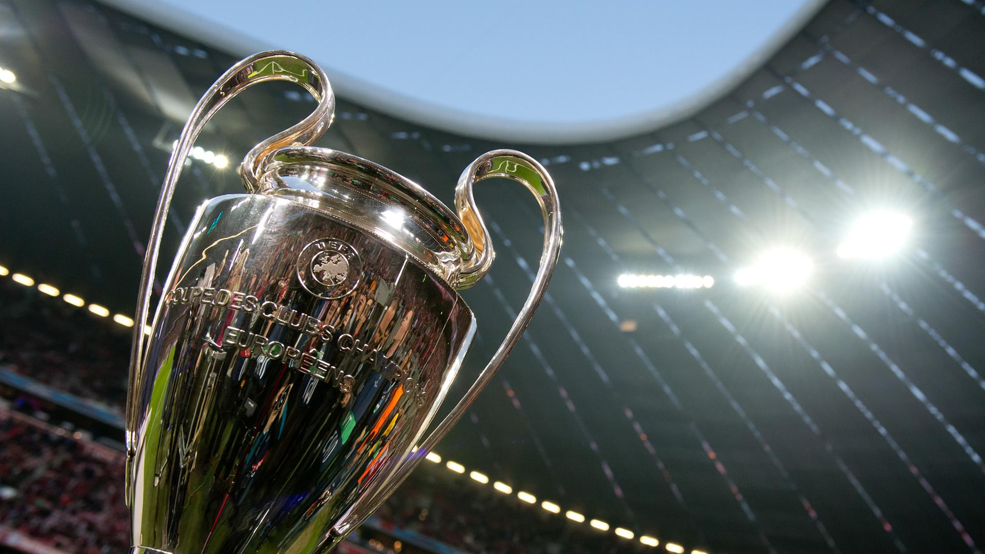 Der Champions-League-Pokal steht auf einem Tisch in einem Stadion.