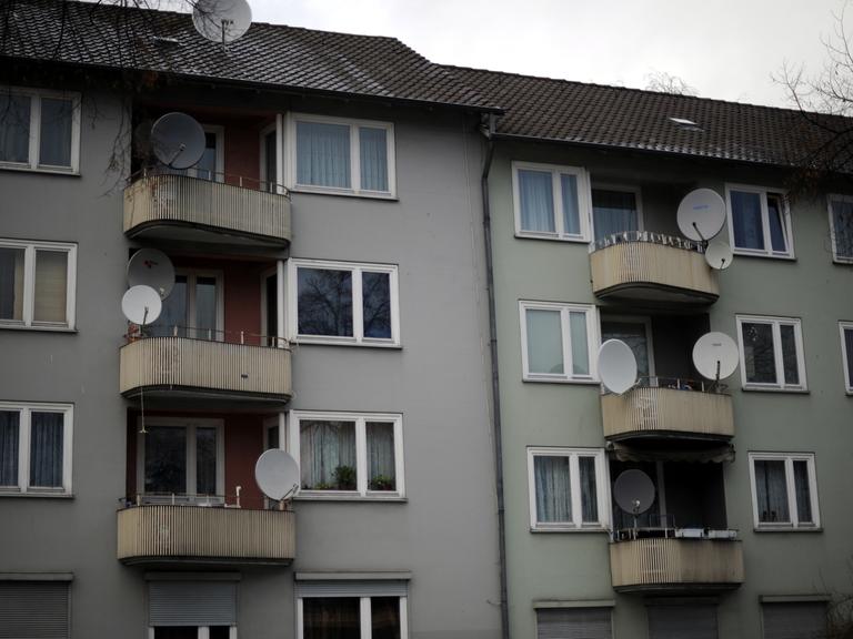 Auf Balkonen eines 50er-Jahre-Mietshauses in Kassel sind zahlreiche Satellitenschüsseln installiert.