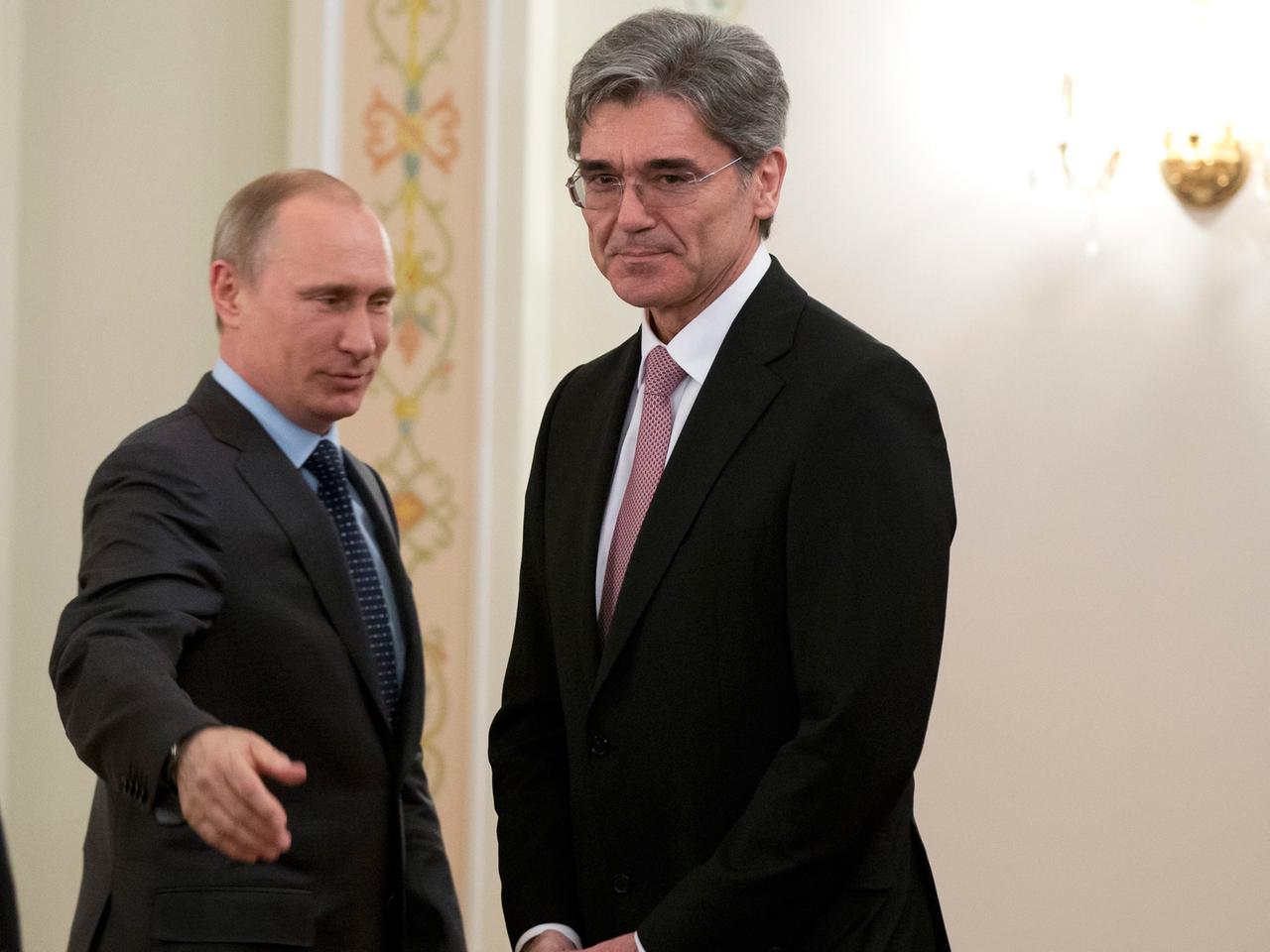 Joe Kaeser und Wladimir Putin, beide im Anzug, stehend, Putin macht eine einladende Armbewegung.