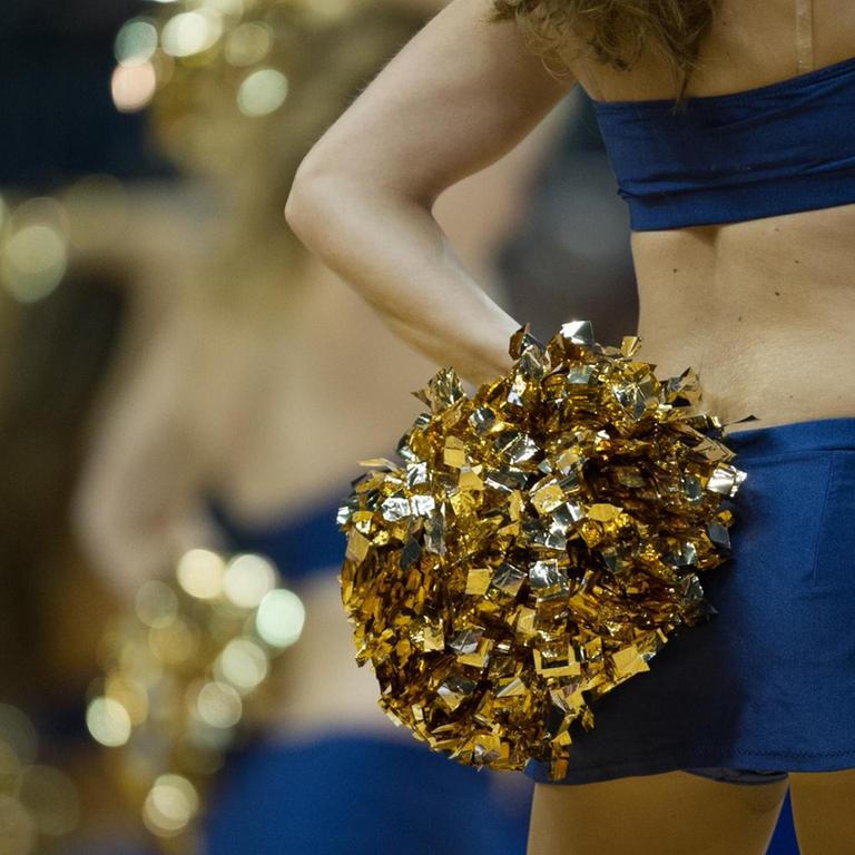 Cheerleader von Alba Berlin in blauen Trikots mit goldenen Puscheln.