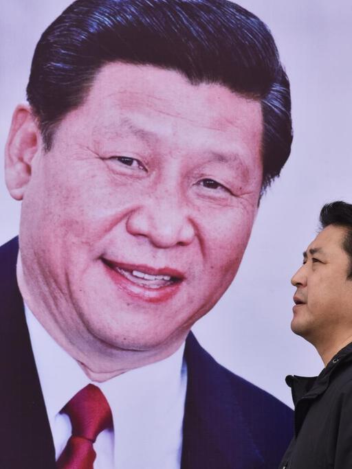 Ein Mann läuft in Peking an einem Poster mit Xi Jinping und der Aufschrift "Chinas Traum, des Volkes Traum" vorbei.