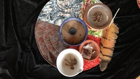 Räucher-Utensilien: weißer Mörser, blaue Räucherschale mit Kohle-Tablette und Quarzsand, Stövchen mit Metallsieb, kleine Schale mit Kräutermischung auf Silberfolie