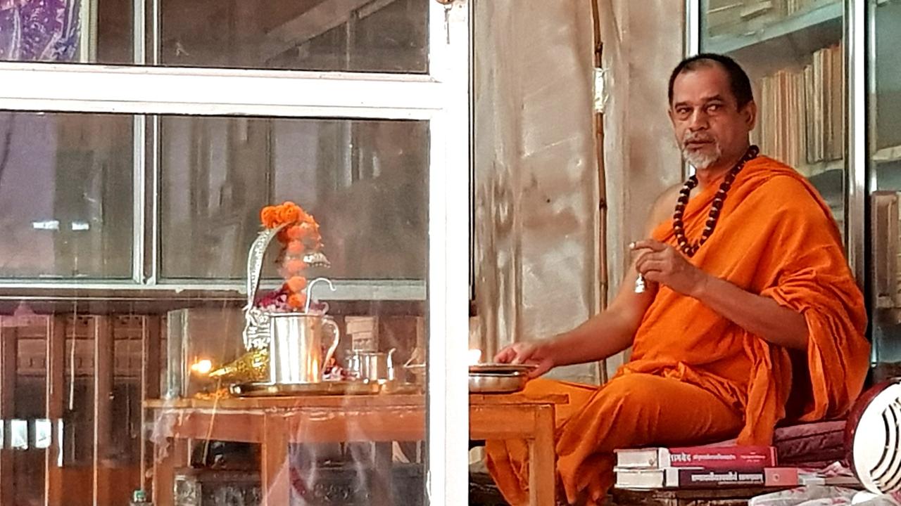 Porträt des hinduistischen Priesters Swami Sadanand Sarasvati in leuchtend orangem Gewand