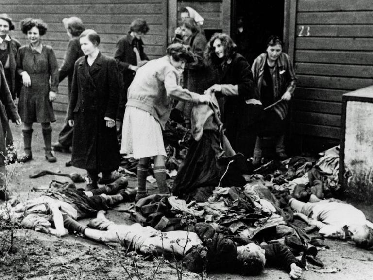 KZ Bergen-Belsen. Befreite Frauen, die sich die Kleidung der Toten holen, nachdem das Lager der Allied 21st Army Group übergeben wurde. Im Lager wurden 55.000 Häftlinge - viele mit Typhus und Ruhr - gefunden. Mehr als 10.000 ehemalige Häftlinge starben nach der Befreiung.
