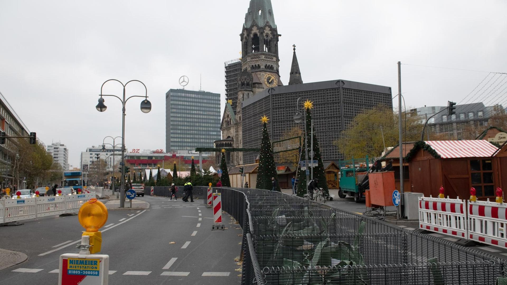 Eisenkörbe mit Sandsäcken gefüllt stehen am Weihnachtsmarkt am Breitscheidplatz. Der Berliner Weihnachtsmarkt an der Gedächtniskirche wird zwei Jahre nach dem islamistischen Terroranschlag mit zwölf Todesopfern aufwendig abgeriegelt.