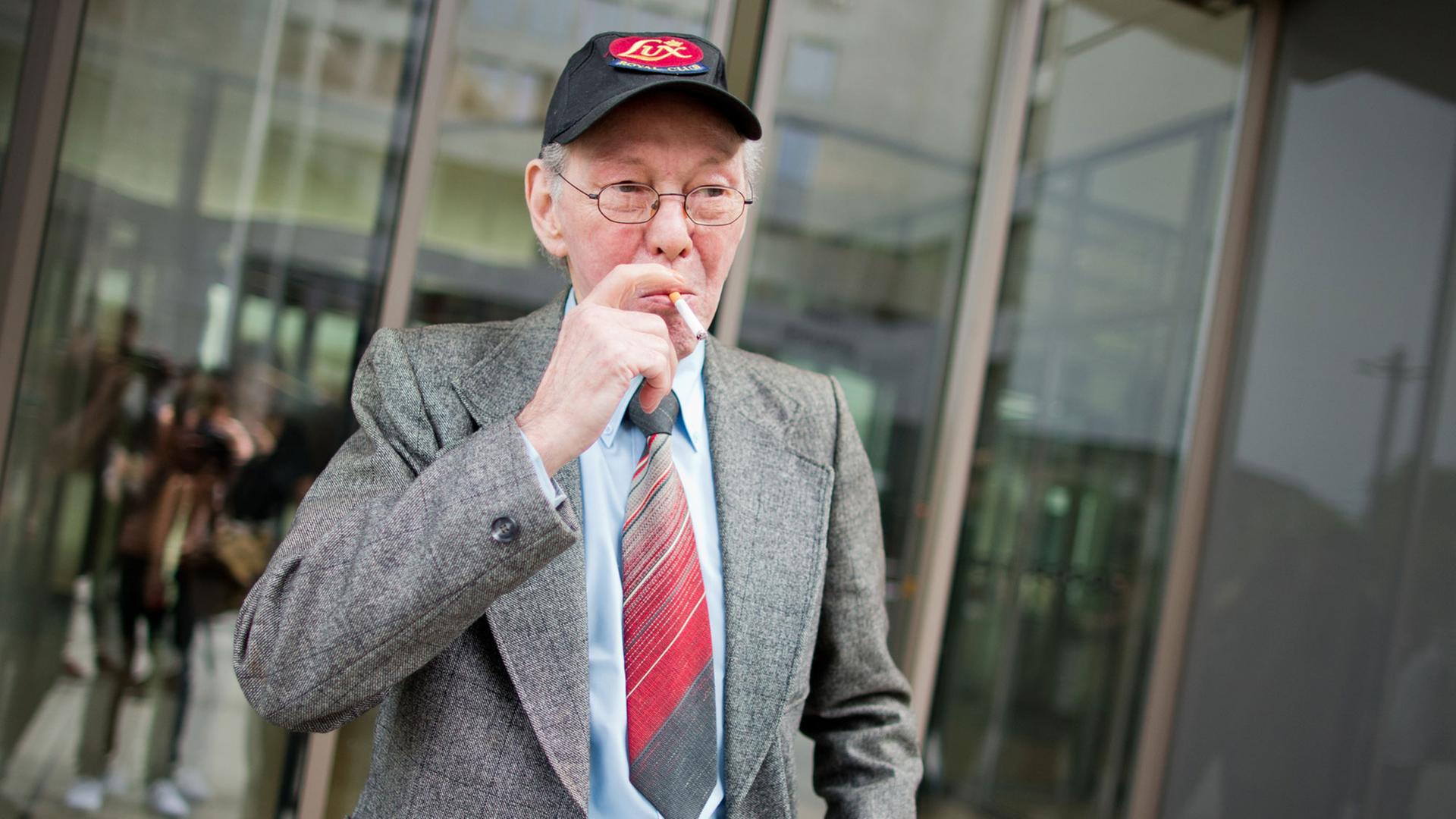 Friedhelm Adolfs raucht demonstrativ vor dem Düsseldorfer Landgericht.