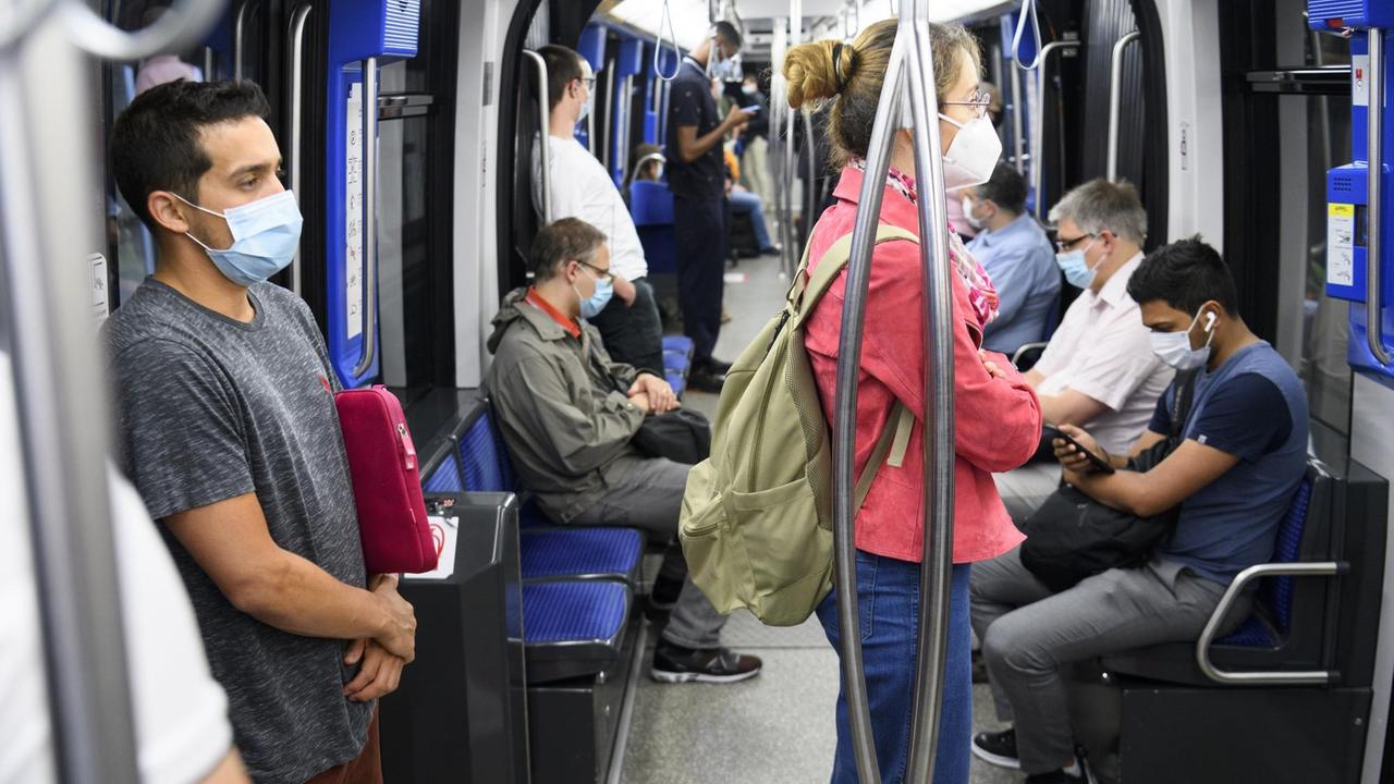 Passagiere in Lausanne tragen Mundschutz während einer Fahrt in der Metro.