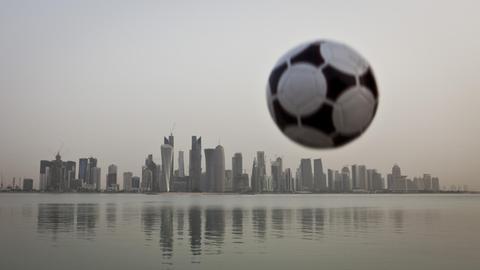 Ein Fußball über der Skyline von Doha, Emirat Katar