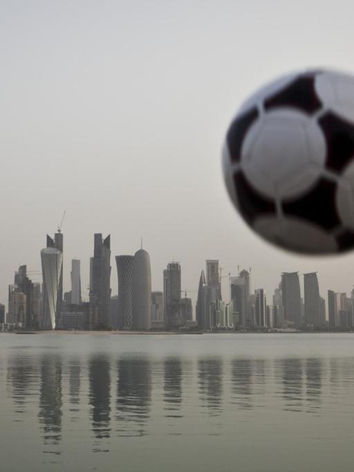 Ein Fußball über der Skyline von Doha, Emirat Katar