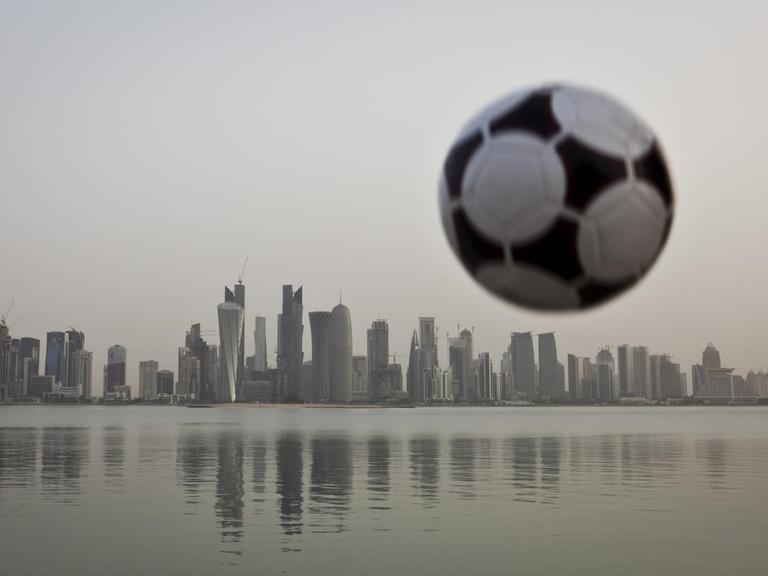 Ein Fußball über der Skyline von Doha, Emirat Katar