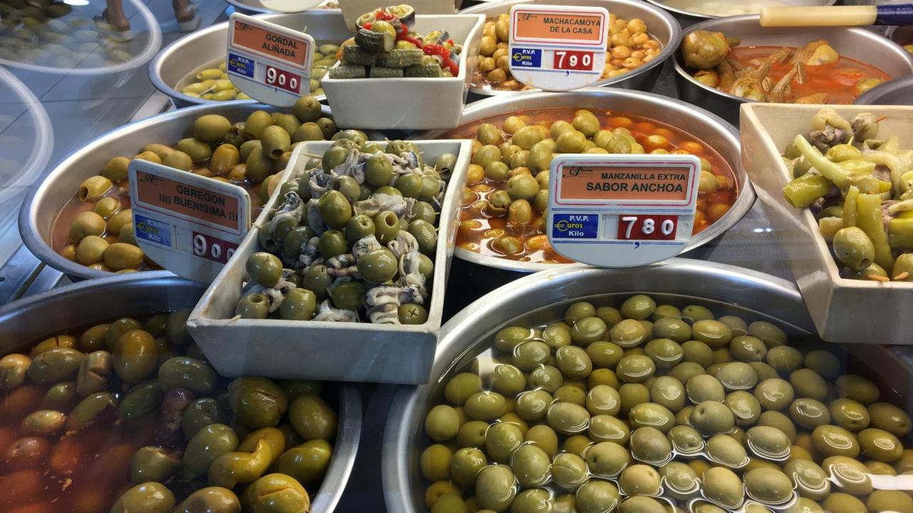 Eingelegte Oliven werden frisch in Schüsseln auf einem Verkaufsstand in der Markthalle "La Paz" von Madrid angeboten
