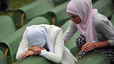 Zwei Frauen an Särgen von Opfern des Massakers von Srebrenica