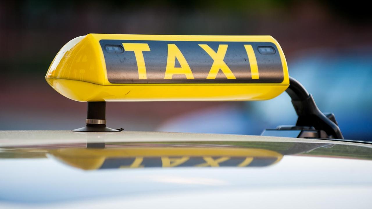 Ein Taxi-Schild auf einem Taxi in Berlin