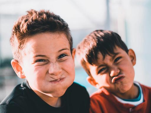 Zwei Jungen ziehen Grimassen.