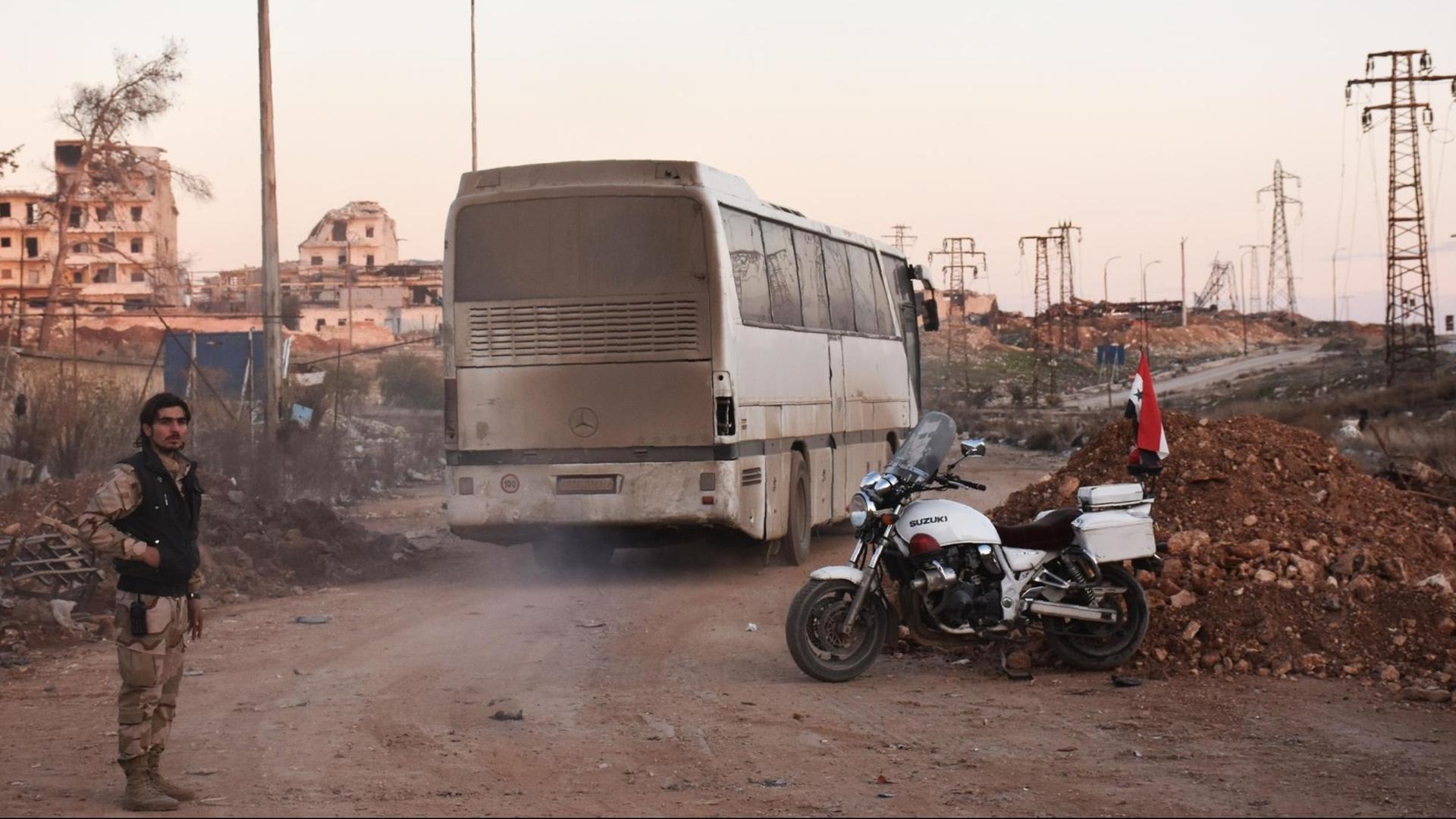 Ein Bus fährt durch die durch das syrische Regime kontrollierten Gebiete von Ramoussa, einem südlichen Außenbezirk von Aleppo, während einer Evakuierungsaktion.