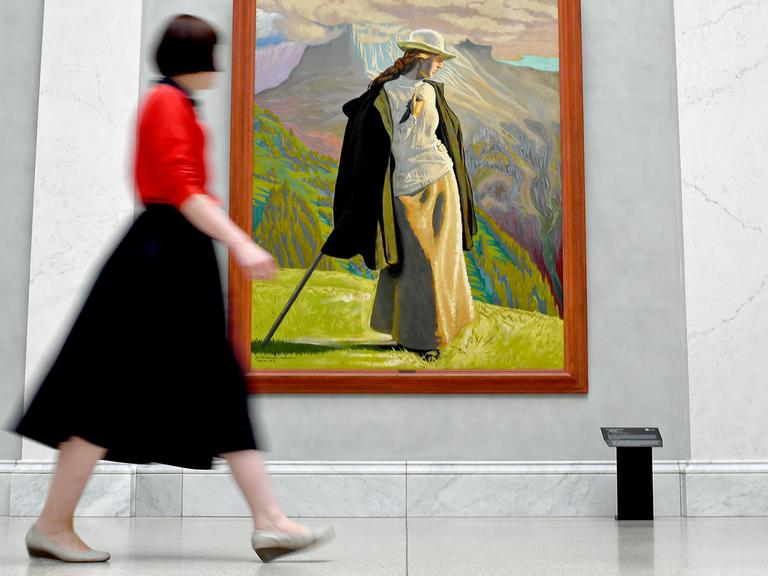 Eine Frau geht an dem Gemälde "Bergsteigerin" des Künstlers Jens Ferdinand Willumsen in der Ausstellung "Wanderlust" in der Alten Nationalgalerie vorbei.