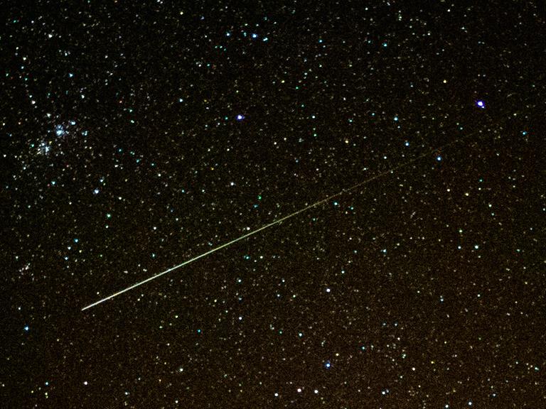 Eine Sternschnuppe leuchtet am Nachthimmel 