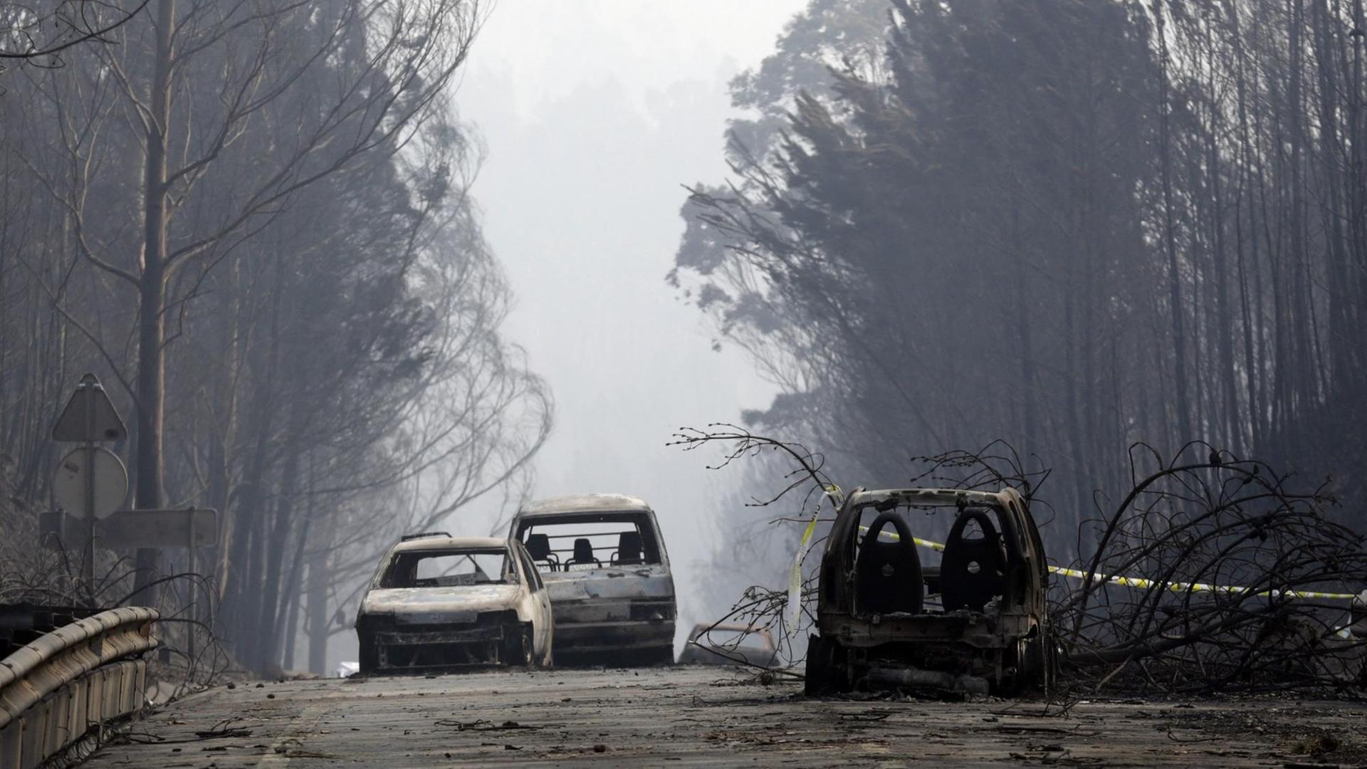 Ausgebrannte Autos stehen am 18.06.2017 auf der Landstraße zwischen Castanheira de Pera und Figueiro dos Vinhos (Portugal). Der verheerende Waldbrand mit mehreren Toten in Portugal ist der Polizei zufolge durch Blitzschlag ausgelöst worden.