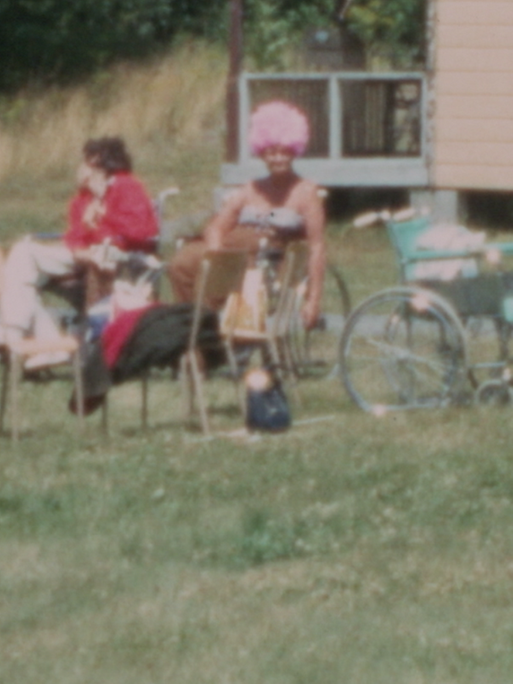 Jugendliche auf einer Wiese, manche sitzen in einem Rollstuhl.