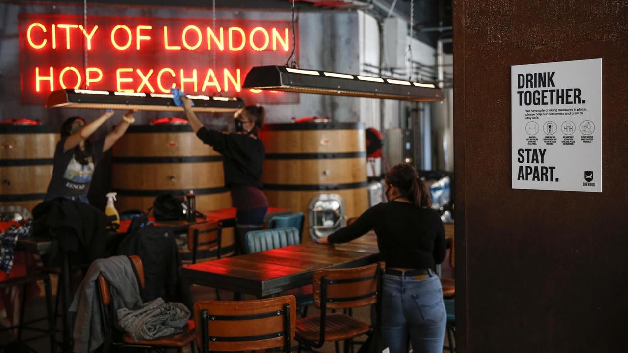 Mitarbeiterinnen bereiten einen Londoner Pub für seine Wiedereröffnung vor.