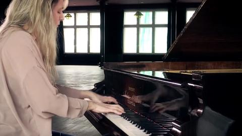 Die Pianistin Ragna Schirmer sitzt vor einem schwarzen Flügel und spielt Musik.
