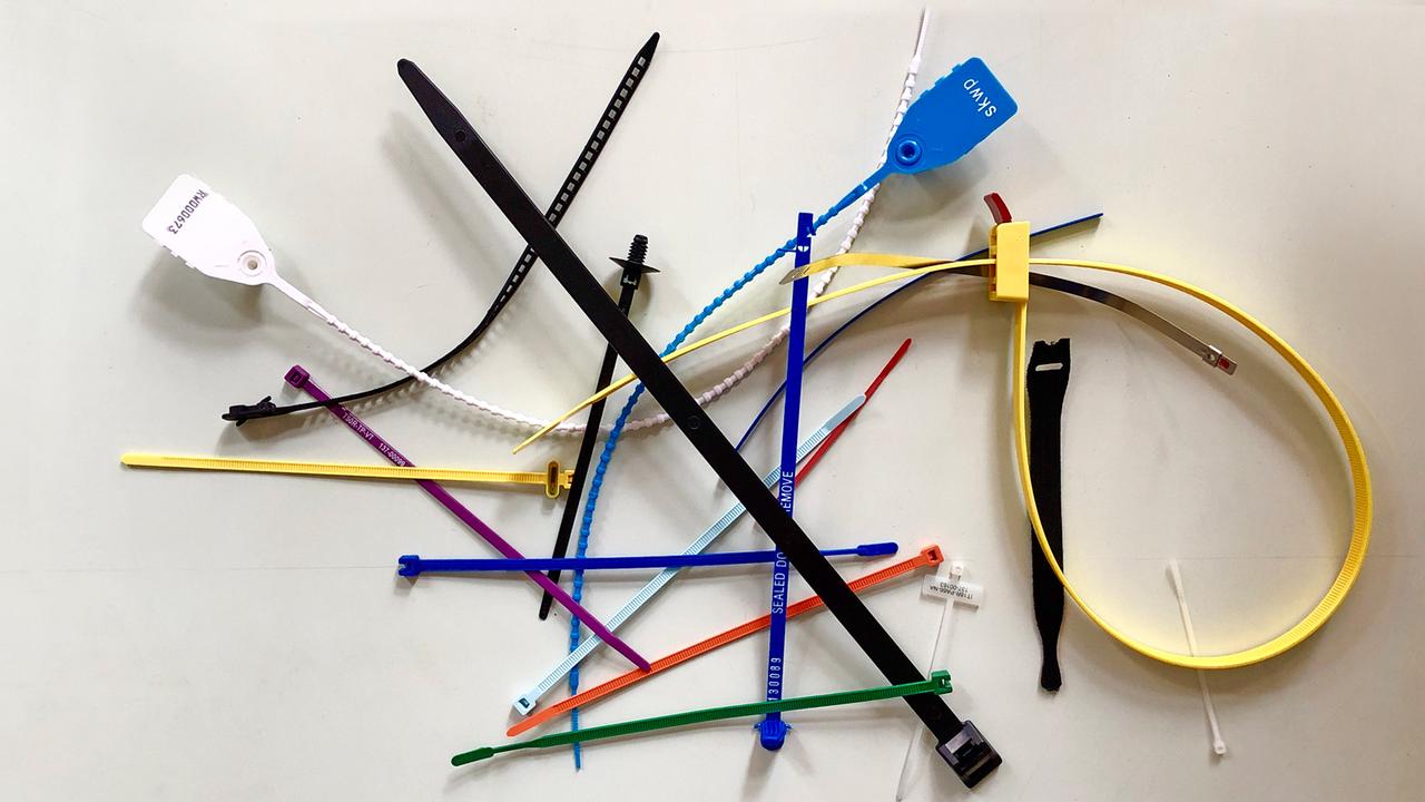 Kabelbinder unterschiedlicher Farben und Größen liegen auf einem losen Stapel.