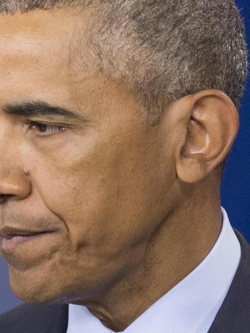 US-Präsident Barack Obama schaut ernst. Er steht vor einer US-Flagge im Weißen Haus.