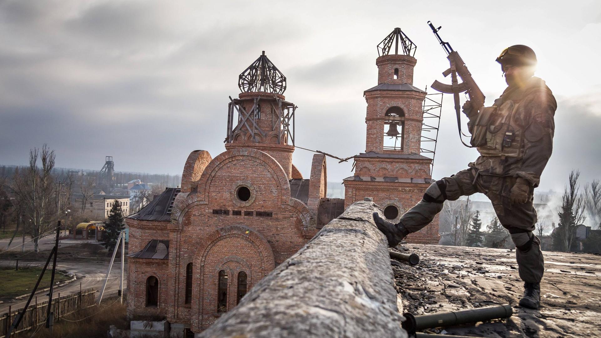 Soldat vor zerstörter Kirche im ukrainischen Dorf Pisky.
