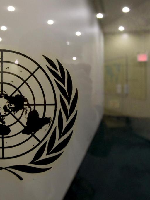 Das Logo der Vereinten Nationen auf einer Glasscheibe in den Räumlichkeiten der Vereinten Nationen in New York