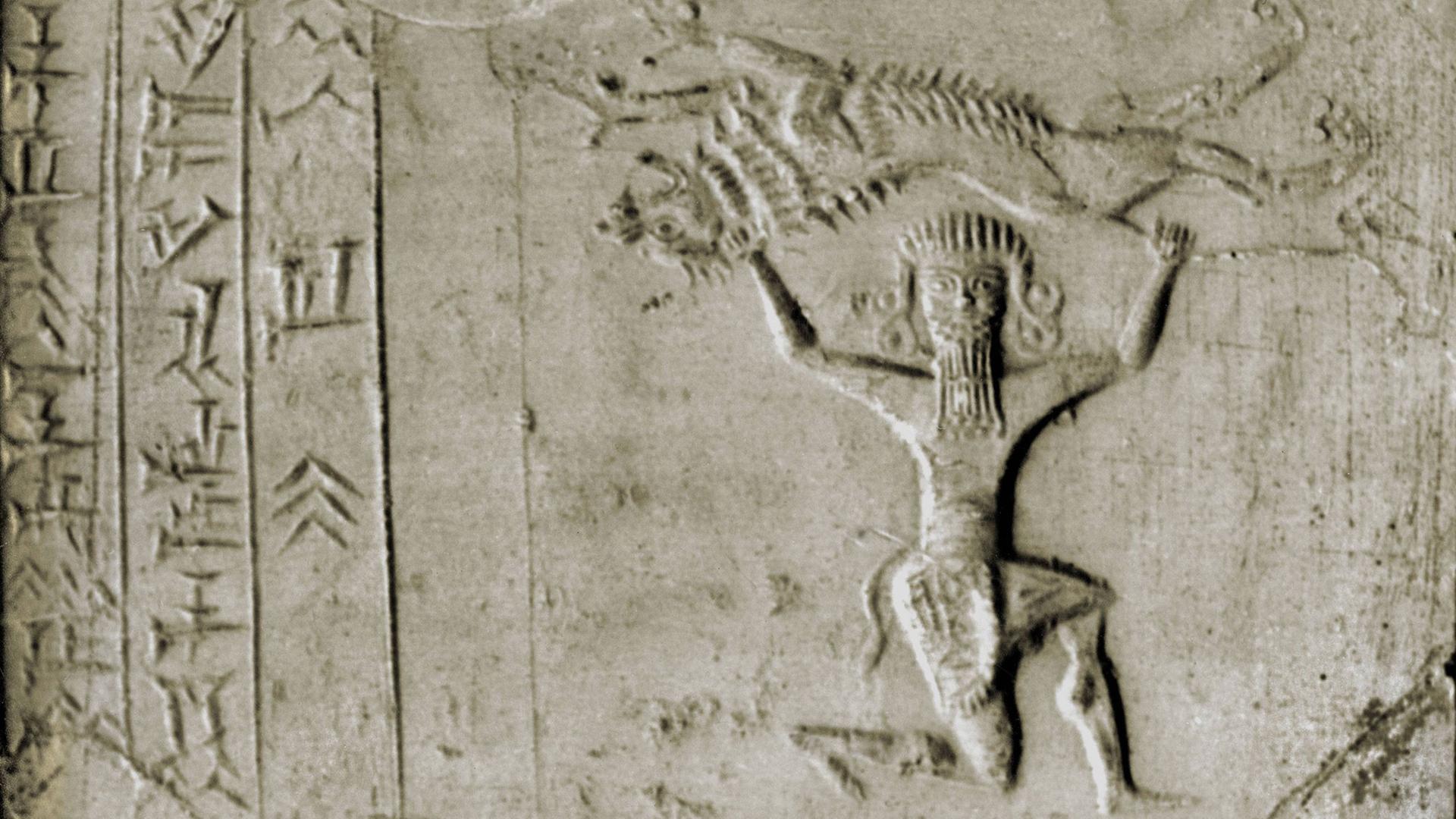 Der bärtige Held Gilgamesh hält kniend einen ausgestreckten Löwen über seinem Kopf.