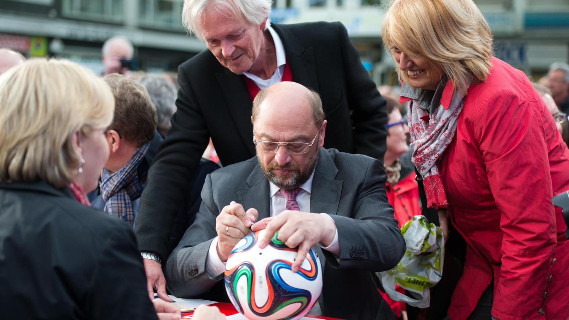 Der Spitzenkandidat der SPD für die Europawahl, Martin Schulz (M) und die nordrhein-westfälische Ministerpräsidentin Hannelore Kraft (l) schreiben am 02.05.2014 in Dortmund (Nordrhein-Westfalen) auf einer Wahlveranstaltung ihrer Partei Autogramme.