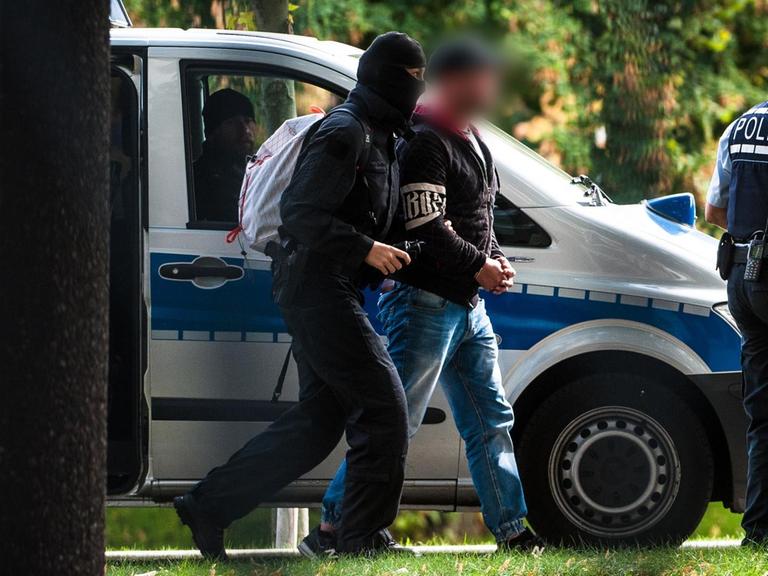 Mutmaßliche Rechtsterroristen, die in Bayern und Sachsen festgenommen wurden, erreichen den Bundesgerichtshof und werden von Polizisten abgeführt.
