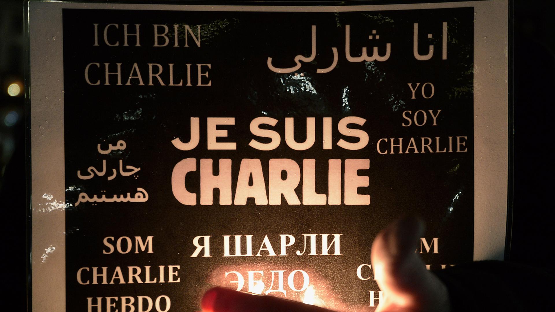 Eine Frau hält ein Poster mit einer Solidaritätsbekundung für "Charlie Hebdo" hoch
