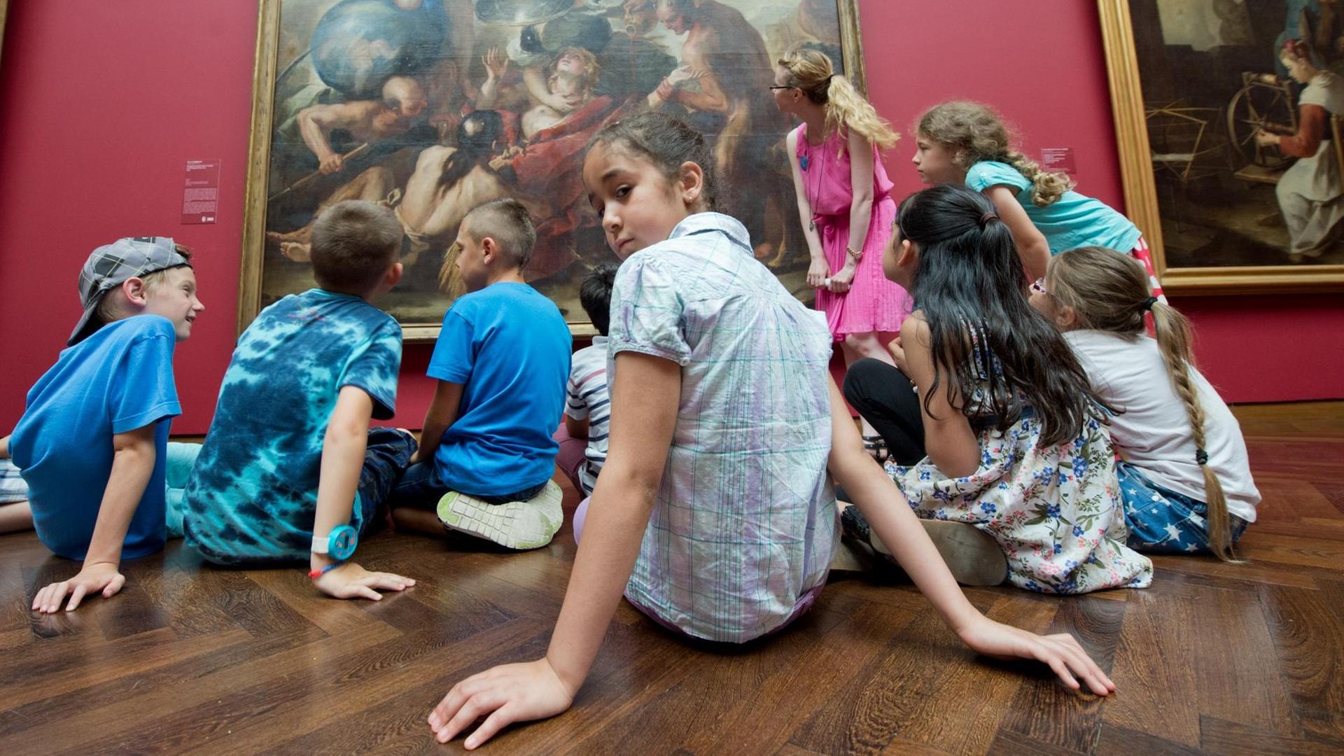 Eine Gruppe von Kindern sitzt im Rahmen eines museumspädagogischen Workshops im Frankfurter Städel Museum vor einem altmeisterlichen Gemälde.