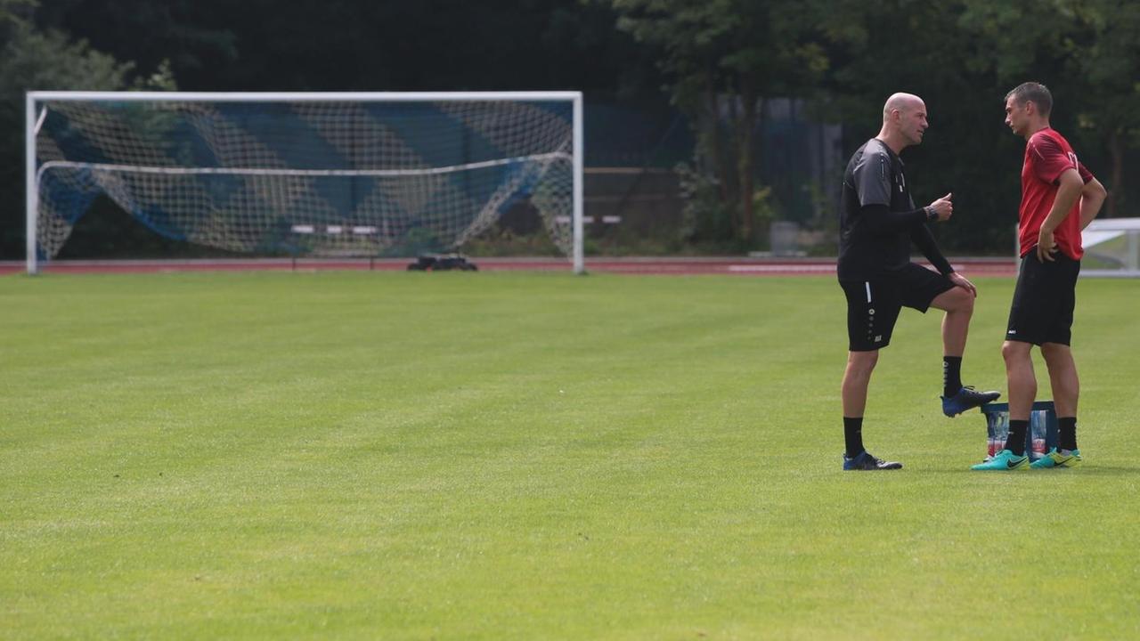 Fußballtrainer Marco Antwerpen von Regionalligist Viktoria Köln im Gespräch mit einem seiner Spieler.