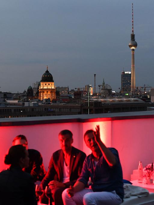 Gäste vor der Skyline von Berlin in der Skylounge vom EWerk in Berlin-Mitte