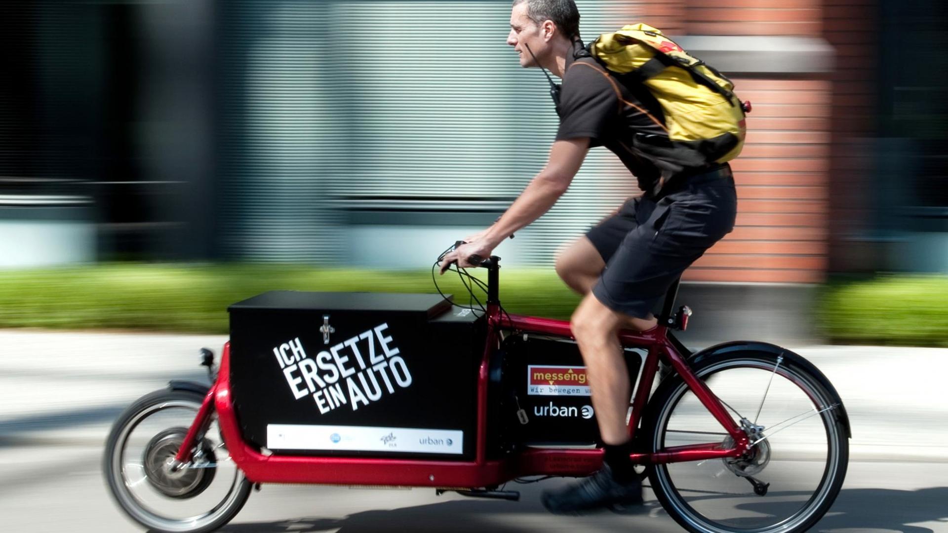 Ein Fahrradkurier fährt auf dem Gelände des EUREF-Campus in Berlin-Schöneberg mit einem Elektrofahrrad namens Lasten-E-Bike iBullitt