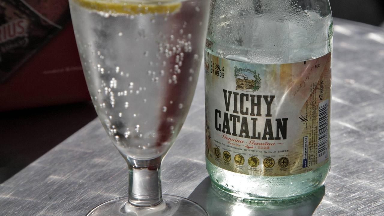 Glas und Flasche von Vichy Catalan-Wasser.