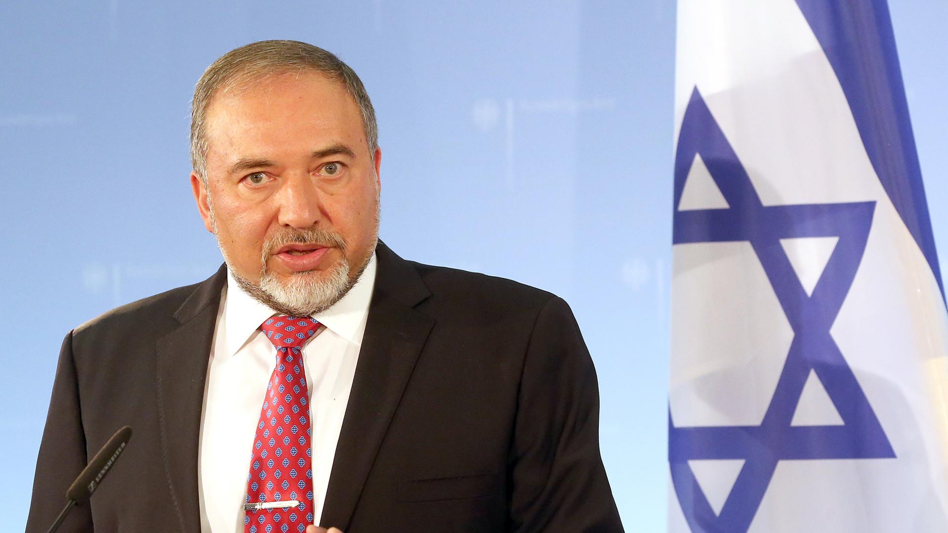 Avigdor Lieberman hält eine Rede, rechts von ihm eine israelische Flagge.