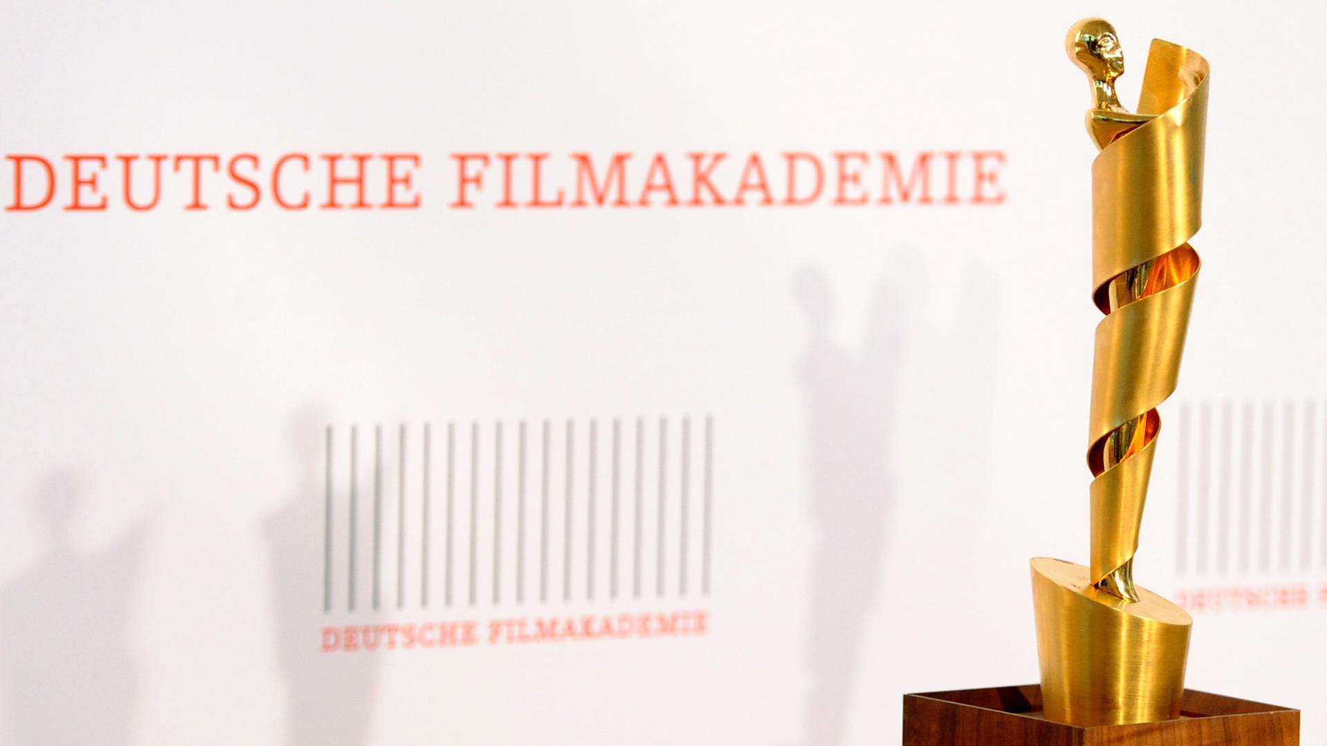 Die "Lola"-Trophäe vor dem Logo der Deutschen Filmakademie