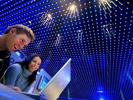 Besucher vergnügen sich an einem Computer während der CeBIT in Hannover