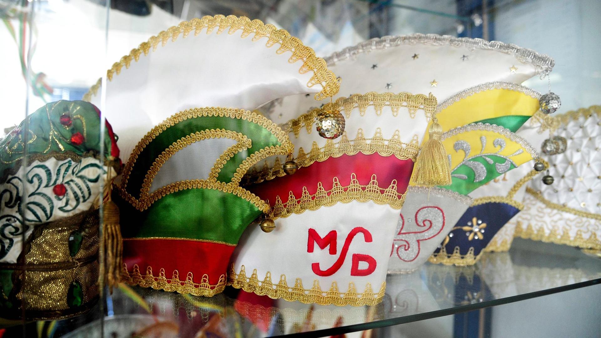 Mützen für Karneval stehen in einer Virtrine der Stickerei und Fahnenfabrik H. u M. Schwarz GmbH in Heusweiler.