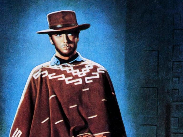Gemaltes Plakatmotiv mit Clint Eastwood in Poncho und cooler Pose vor blau illuminiertem Hintergrund.